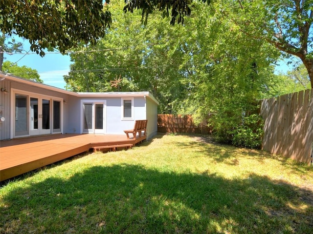 view of yard featuring french doors and a deck