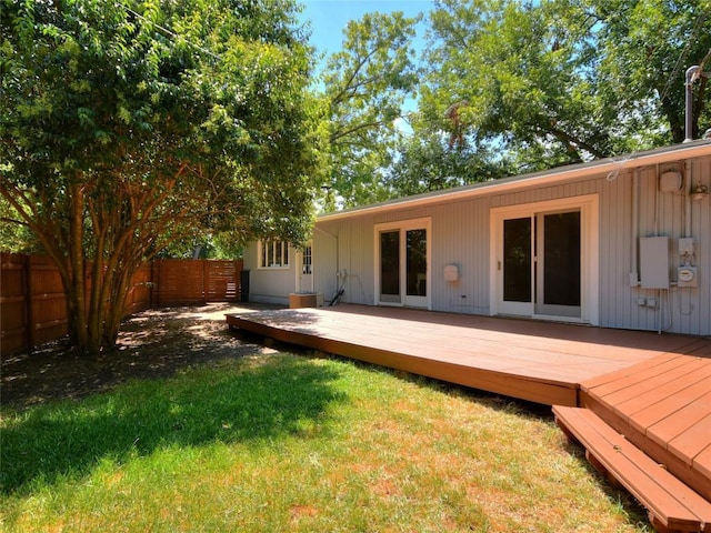 back of house with a deck and a lawn