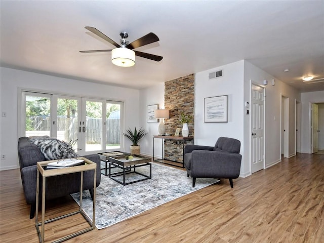 living room featuring hardwood / wood-style flooring, ceiling fan, and french doors