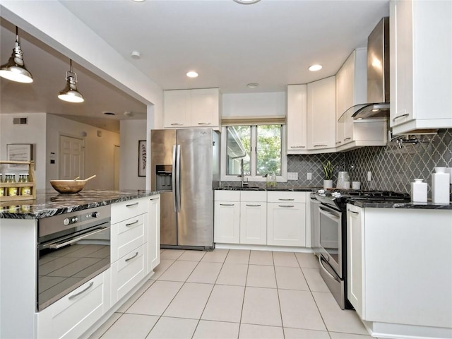 kitchen with wall chimney exhaust hood, white cabinetry, and stainless steel appliances