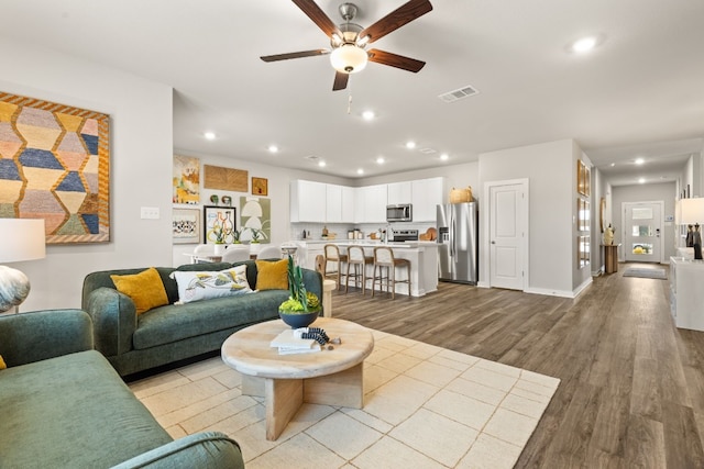 living room with ceiling fan and light hardwood / wood-style floors