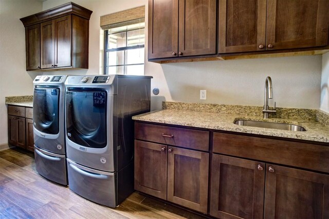 washroom featuring cabinets, sink, and washing machine and clothes dryer