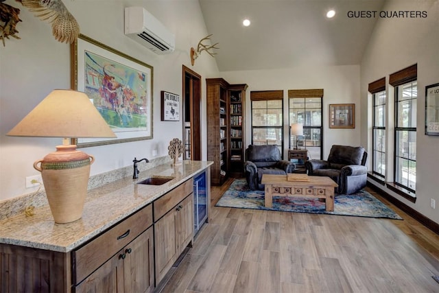 interior space featuring sink, a wall unit AC, high vaulted ceiling, wine cooler, and light wood-type flooring