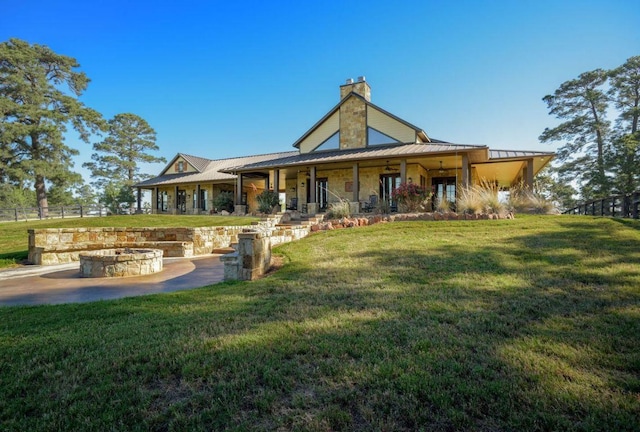 0000 Gotier Trace Rd, Smithville, TX 78957 - rear view of house featuring a fire pit, a chimney, a standing seam roof, and metal roof