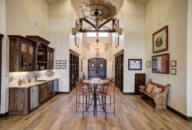 0000 Gotier Trace Rd, Smithville, TX 78957 - dining room with a high ceiling, baseboards, wine cooler, and light wood finished floors