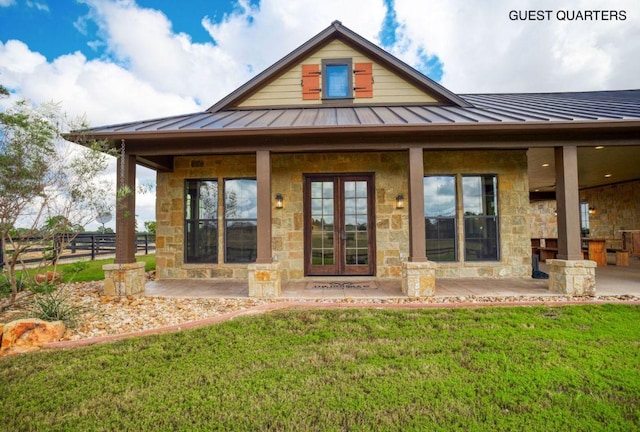 0000 Gotier Trace Rd, Smithville, TX 78957 - back of house featuring a standing seam roof, stone siding, metal roof, and a patio area
