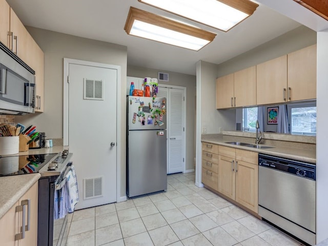 kitchen with light tile patterned floors, stainless steel appliances, sink, and light brown cabinets