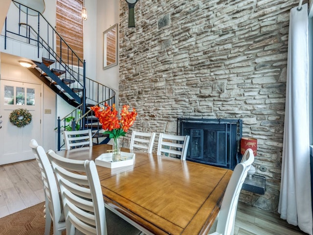 2102 W 11th St Unit A, Austin, TX 78703 - dining area with a high ceiling, wood finished floors, stairs, and a glass covered fireplace