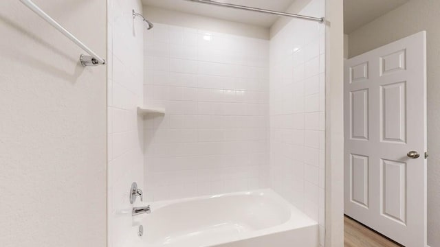 bathroom with tiled shower / bath and wood-type flooring