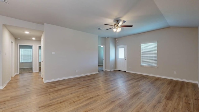 empty room featuring vaulted ceiling, ceiling fan, plenty of natural light, and light hardwood / wood-style floors