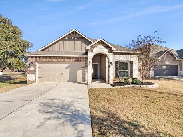 116 San View Dr, Georgetown, TX 78628 - view of front of house featuring concrete driveway, a garage, a front lawn, board and batten siding, and brick siding