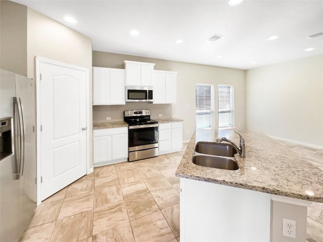 116 San View Dr, Georgetown, TX 78628 - kitchen featuring stainless steel appliances, a kitchen island with sink, light stone counters, white cabinets, and recessed lighting