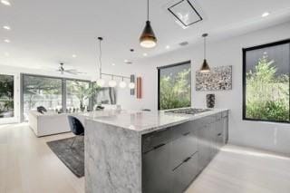 kitchen with open floor plan, plenty of natural light, hanging light fixtures, and modern cabinets