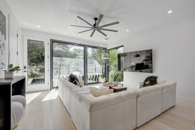 living room with light hardwood / wood-style floors and ceiling fan