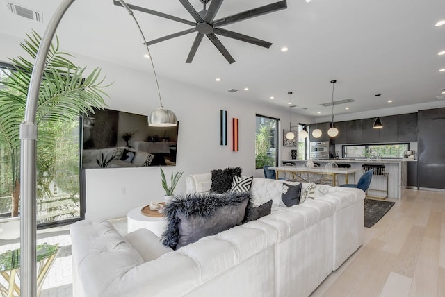 living area with visible vents, ceiling fan, light wood-style flooring, and recessed lighting