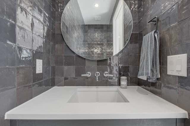 bathroom featuring vanity and tile walls