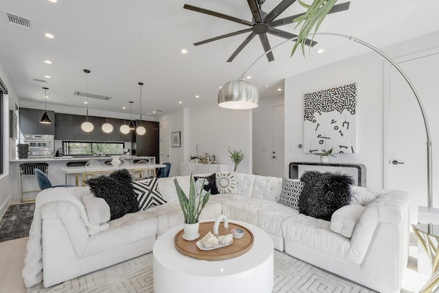 living area with ceiling fan, visible vents, and recessed lighting