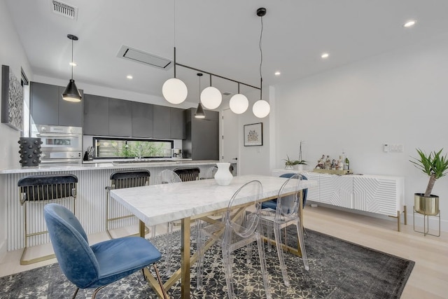 dining room featuring light wood finished floors, visible vents, and recessed lighting