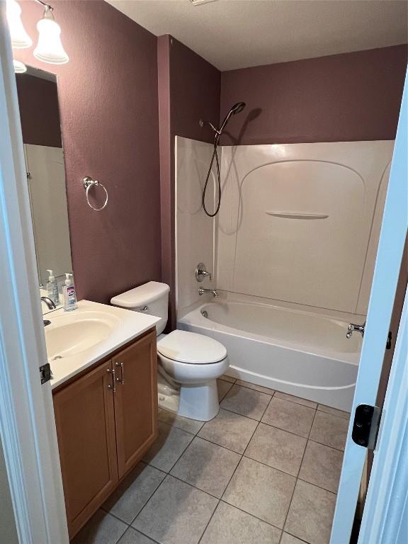 full bathroom with tile patterned flooring, vanity, bathtub / shower combination, and toilet