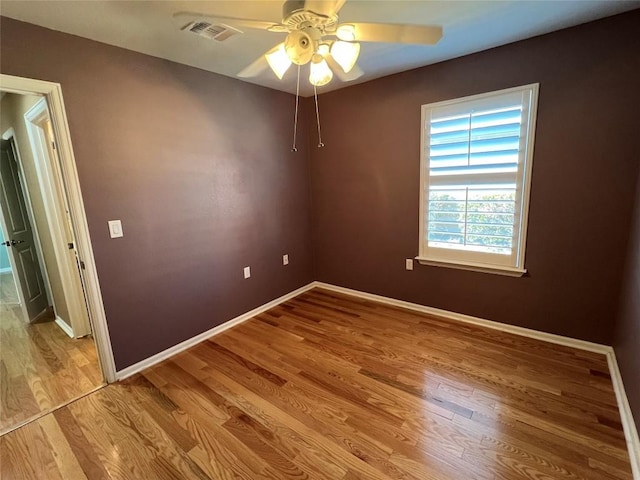 empty room with ceiling fan and light hardwood / wood-style floors