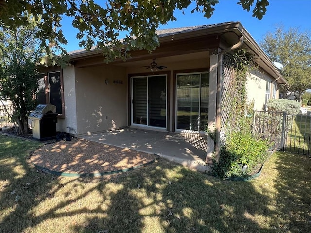 back of property with ceiling fan, a patio, and a lawn