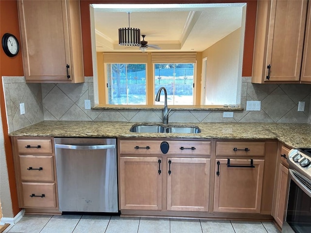 kitchen with sink, appliances with stainless steel finishes, light stone counters, tasteful backsplash, and a tray ceiling