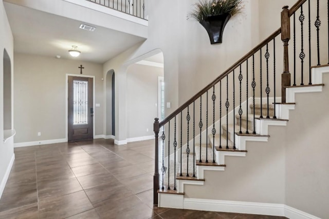 tiled foyer featuring a high ceiling