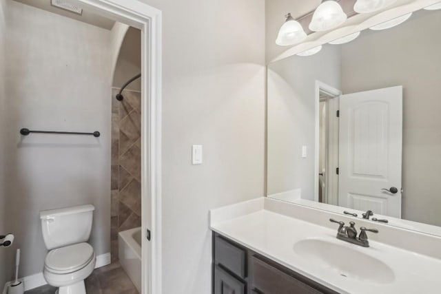 full bathroom with tiled shower / bath, vanity, and toilet