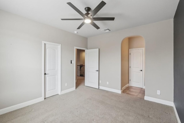 unfurnished bedroom featuring light colored carpet and ceiling fan