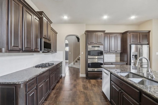 kitchen featuring stainless steel appliances, sink, and dark brown cabinetry