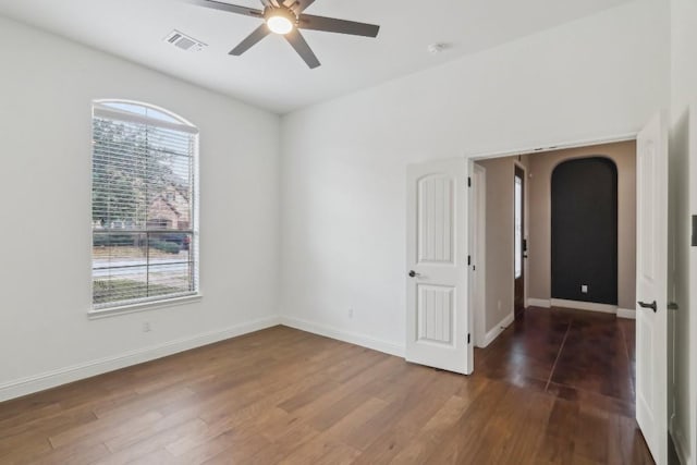 unfurnished room with dark wood-type flooring and ceiling fan