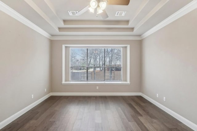 spare room featuring a tray ceiling, dark hardwood / wood-style floors, and ceiling fan