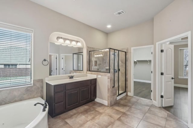 bathroom featuring plus walk in shower, vanity, and tile patterned floors