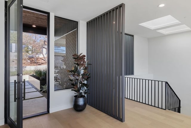 4502 Hyridge Dr, Austin, TX 78759 - doorway to outside with a skylight, wood finished floors, a wall of windows, and recessed lighting
