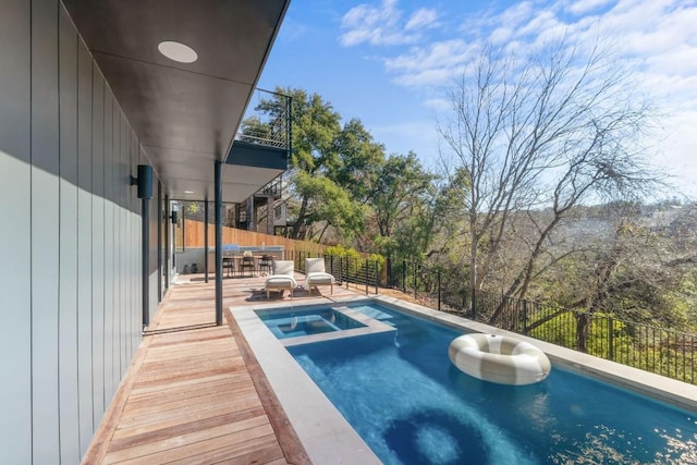 view of swimming pool with an in ground hot tub