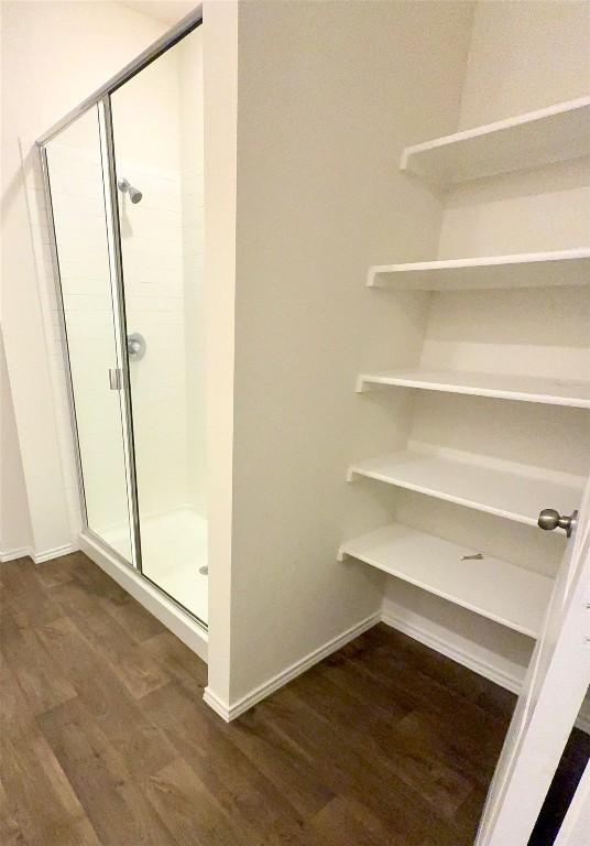 bathroom with wood-type flooring and an enclosed shower