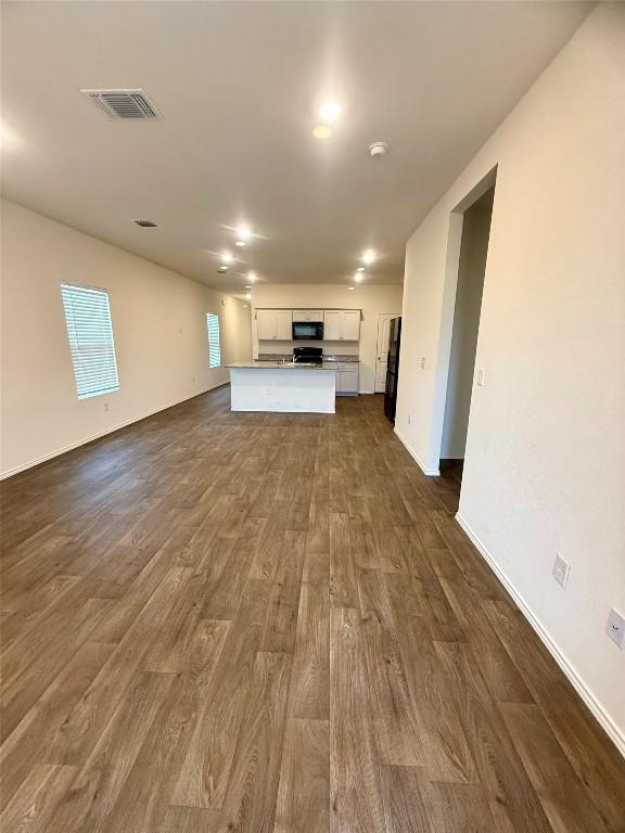 unfurnished living room with dark wood-type flooring