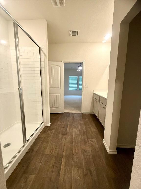 bathroom featuring hardwood / wood-style flooring, vanity, and a shower with door