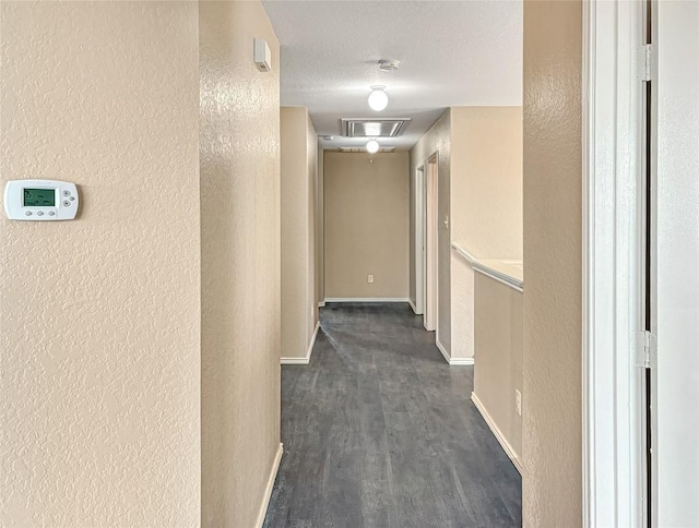 hallway with dark hardwood / wood-style floors and a textured ceiling