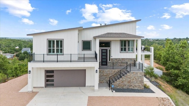 117 Nakalele Ln, Bastrop, TX 78602 - contemporary home featuring a garage, concrete driveway, stone siding, and board and batten siding