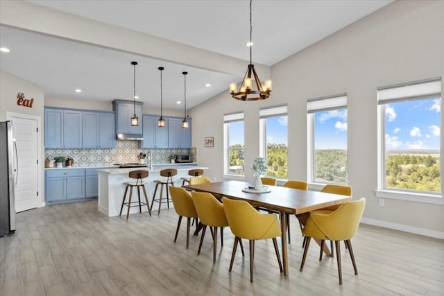 117 Nakalele Ln, Bastrop, TX 78602 - dining space featuring light wood-style floors, a chandelier, recessed lighting, vaulted ceiling, and baseboards