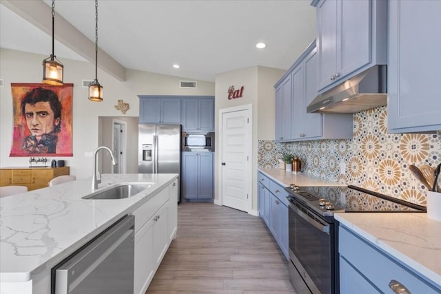 kitchen featuring vaulted ceiling, sink, backsplash, light stone counters, and stainless steel appliances