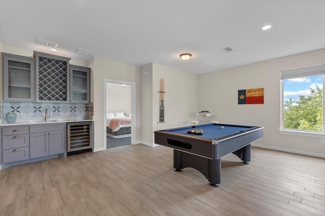 game room with billiards, beverage cooler, light hardwood / wood-style flooring, and wet bar