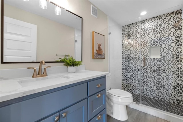 bathroom with vanity, wood-type flooring, toilet, and walk in shower