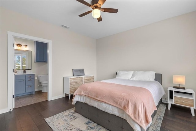 bedroom with dark wood-type flooring, ceiling fan, and connected bathroom