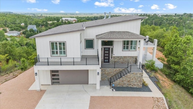 117 Nakalele Ln, Bastrop, TX 78602 - modern home with a shingled roof, an attached garage, driveway, a balcony, and stone siding