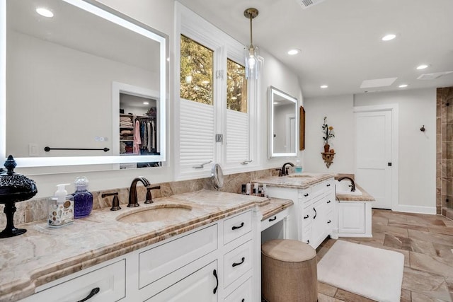 1027 Challenger, Lakeway, TX 78734 - full bath featuring vanity, stone tile floors, recessed lighting, tiled shower, and a spacious closet