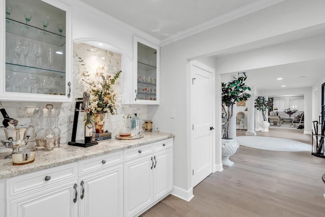 1027 Challenger, Lakeway, TX 78734 - indoor dry bar with light wood-style floors, ornamental molding, tasteful backsplash, baseboards, and recessed lighting