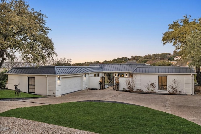 1027 Challenger, Lakeway, TX 78734 - view of front of home featuring a standing seam roof, driveway, metal roof, a lawn, and a garage