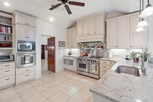 kitchen featuring appliances with stainless steel finishes, lofted ceiling, sink, decorative backsplash, and hanging light fixtures